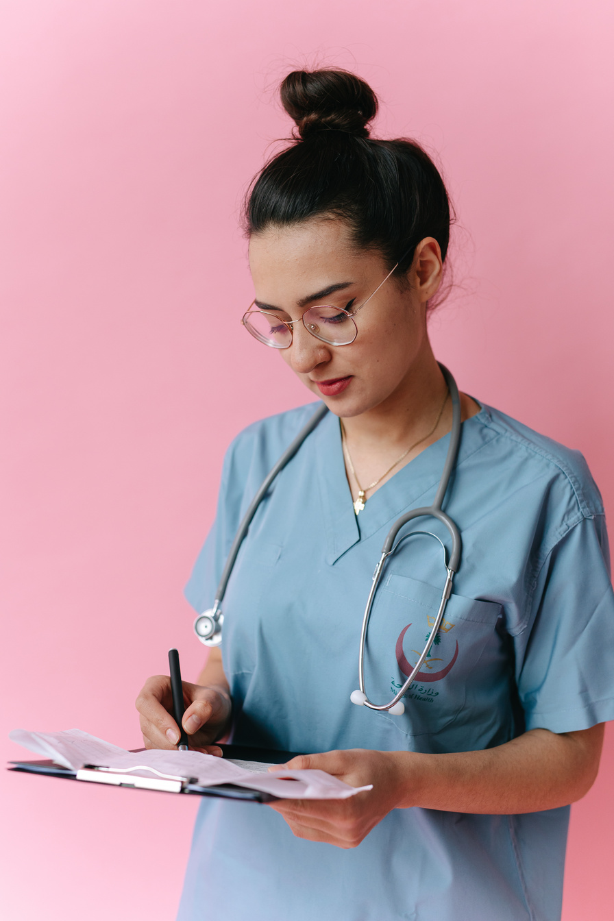 Woman in Blue Scrub Suit Holding Pen